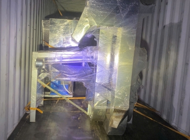 Packing a container of processing machinery for shipment to Tanzania.